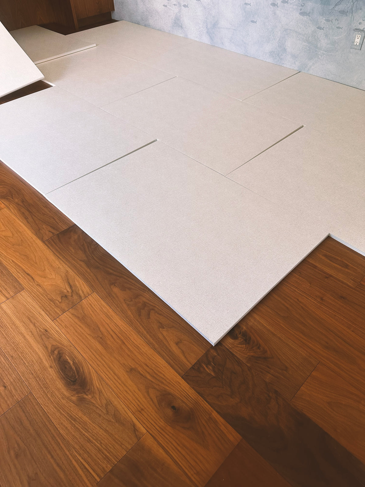 Matnificent tiles being laid over a hardwood floor during an install