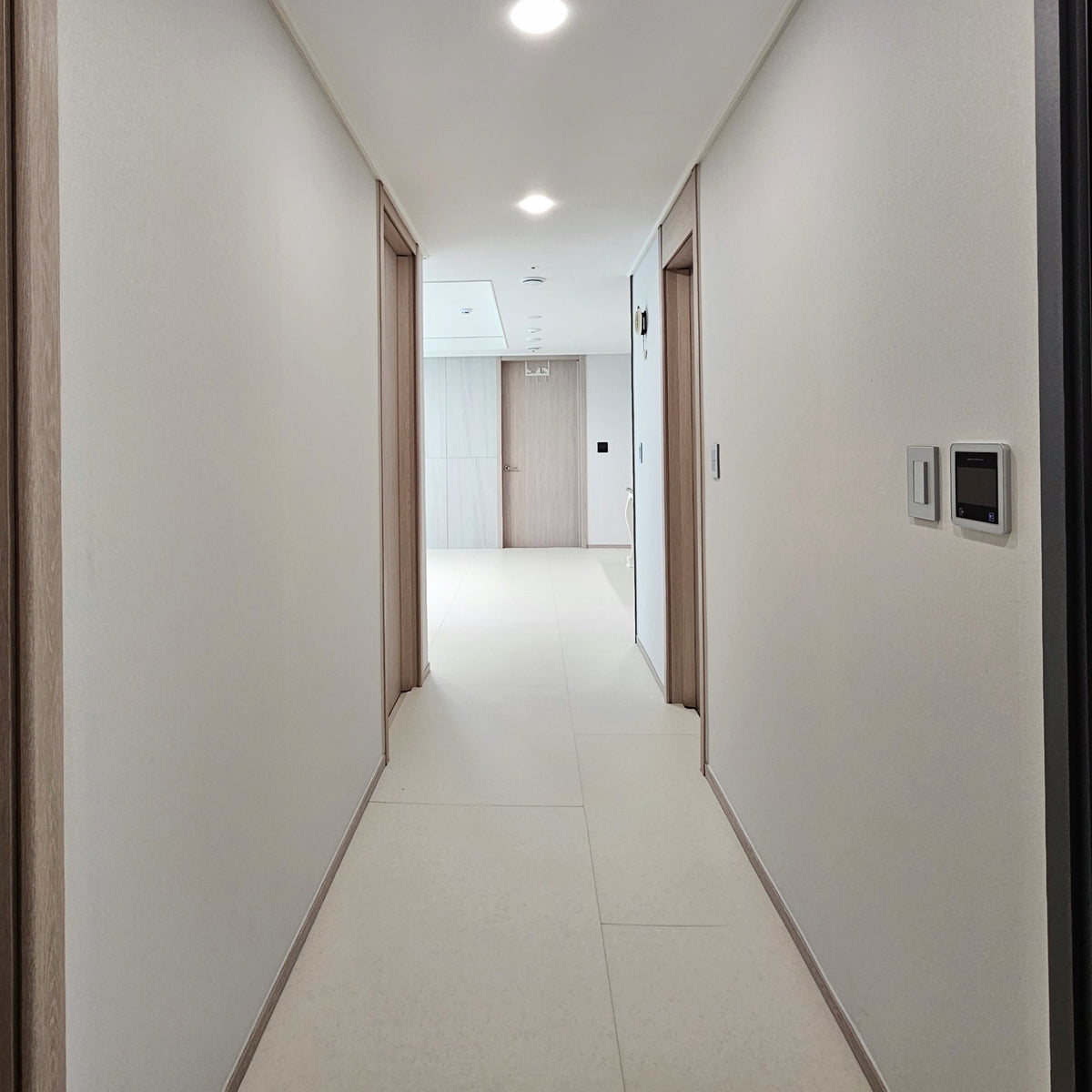 A long hallway with a soft floor fitted wall to wall